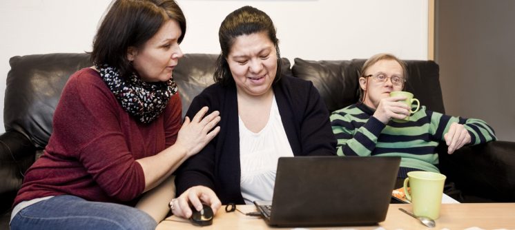 healthcare-worker-helping-woman-with-down-syndrome-XM3VAPY-scaled